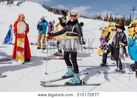 Sheregesh, Kemerovo region, Russia - April 22, 2017: Grelka Fest is a sports and entertainment activity for ski and snowboard riders in carnival costume. Woman on ski in carnival costume of dragonfly.