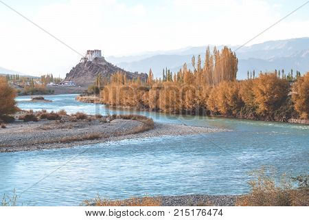 Stakna Gompa and Indus river before sunset with cloudy sky and mountains background