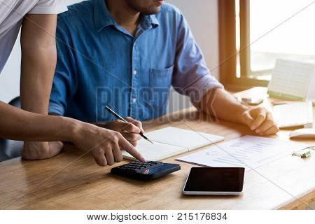 Calculate budget and business planning concept two people couting revenue and expenditure by using calculator and looking paper graph on desk in home office