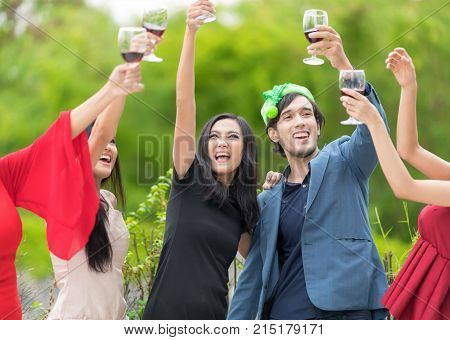 Funny People celebrating happy drinks with friends.Red wine Christmas party concept. Happy new year coming soon.Cheers.