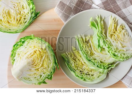 fresh green cut head of cabbage on ceramic gray plate, wooden and material background