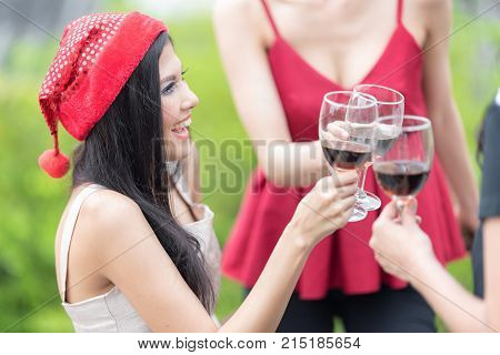 Red wine Christmas party concept. Happy new year coming soon.Closeup of of People hands holding glass celebrating happy drinks with friends.