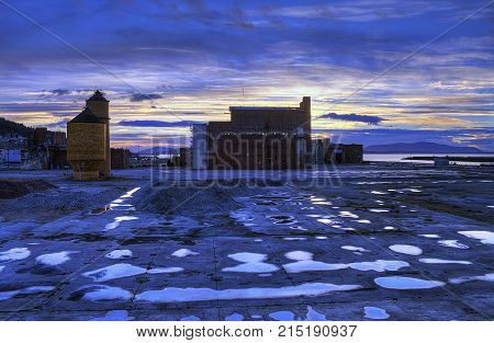 Pool of rain water reflect the demise of the Port of Bellingham.