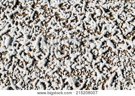 The texture of the frozen dirt of the winter roads. Forest road after threat of cold weather and snow. The texture of the snow surface.