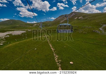 Aerial ropeway high in the mountains of Caucasus with grass plains and cow pastures in the background