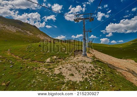 Aerial ropeway high in the mountains of Caucasus with grass plains and cow pastures in the background