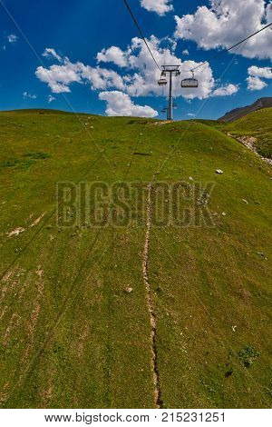 Aerial ropeway high in the mountains of Caucasus with grass plains and cow pastures in the background