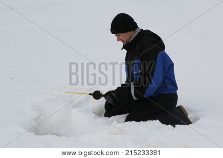 ROVANIEMI, FINLAND - FEBRUARY 17, 2017: Unidentified fisherman during ice fishing on the frozen lake in Lapland, Finland