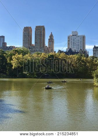 A big lake with one boat and buildings in backgroung