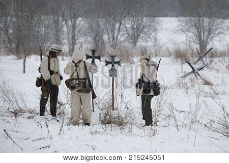 KRASNOE SELO, RUSSIA - JANUARY 15, 2017: The German infantrymen of the period of World War II at the field cemetery. Fragment of military and historical reconstruction of fights for lifting the siege of Leningrad