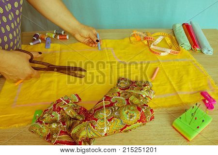 Tailor woman working in his tailor shop Tailoring. A tailor is laying out a dress/Sewing layout