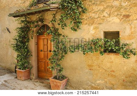 Wall of an old stone house decorated with flowers Italy