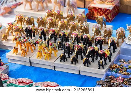 Closeup image of different colorful souvenirs in Indian market with metal figures of Indian goddess