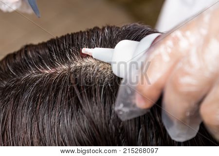 Hair Dresser Applying Chemical Hair Color Dye Onto Hair Roots