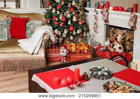 Cozyness And Home Comfort. Sofa Near The Decorated Christmas Tree And Fireplace With Firewood. Winte