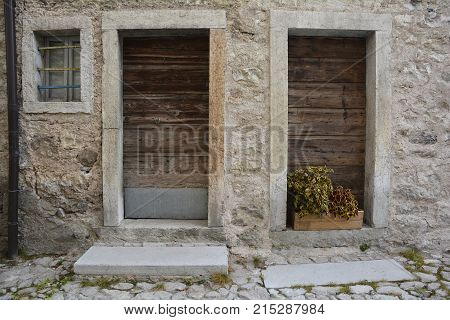 Old wooden doors in disused buildings the historic hill village of Erto in Friuli Venezia Giulia north east Italy