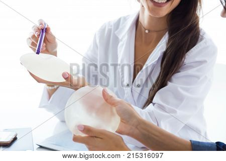 Doctor And Her Patient Choosing Mammary Prosthesis In The Office.
