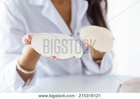Female Doctor Choosing Mammary Prosthesis In The Office.