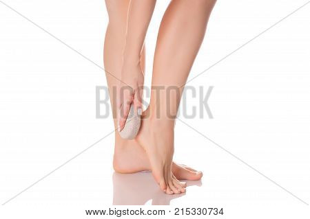 Female feet heel stone pumice on white background isolation