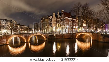 Beautiful night scene in Amsterdam at Keizersgracht and Leidsegracht with illuminated bridges in winter. This spot is a famous Photo-Location.