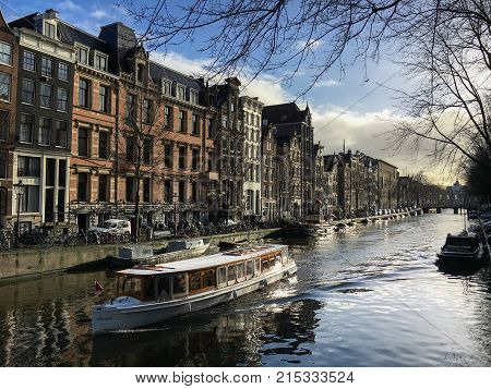 Amsterdam, Netherlands - January 14, 2017: Canal in Amsterdam with a boat on a sunny day in winter