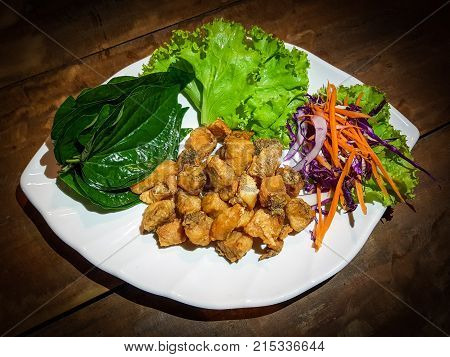 Red Snapper Fish chop and deep fry in a white plate with salad and betal leaf