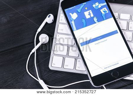 Sankt-Petersburg Russia November 25 2017: Apple iPhone 7 with Facebook homepage on monitor screen. Facebook one of the biggest social network website. Homepage of Facebook.com on smartphone