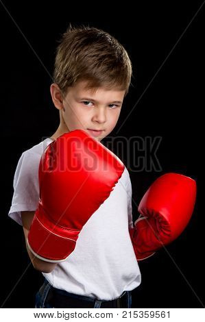 An angry, confident boxer with red gloves. The defend position portrait on the black background.