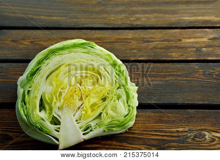 Slice a head of Iceberg lettuce on wooden floor