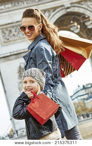 Stylish autumn in Paris. happy modern mother and child with shopping bags in Paris France