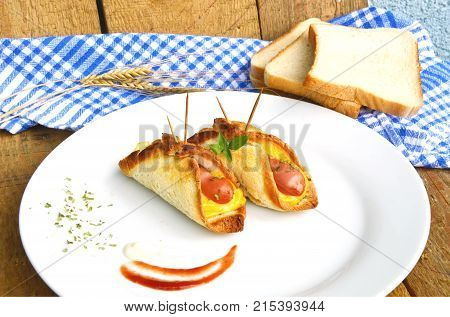 Toasted Hot Dogs and Cheese on white dish and wheat with fresh toast on wooden background
