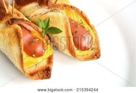Toasted Hot Dogs and Cheese on white dish and wheat with fresh toast on wooden background