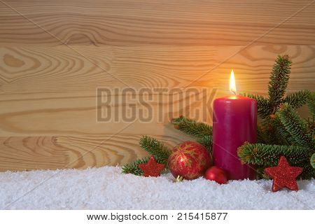 Avent candle and red christmas decoration isolated on wood background. Christmas background with snow, candle and red star.