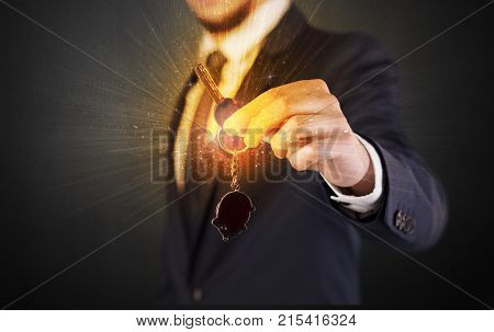 Formal man hand over shiny keys with dark background