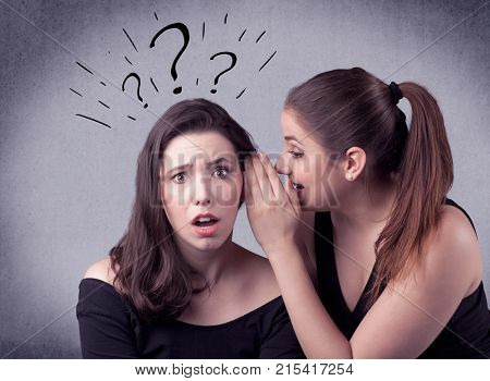 A teenager girl looking confused with drawn question marks above the head, while a girlfriend whispers something in her ear concept.