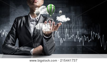 Closeup of business woman in suit presenting flying aerostate among clouds in her palm with business sketches on background. 3D rendering.