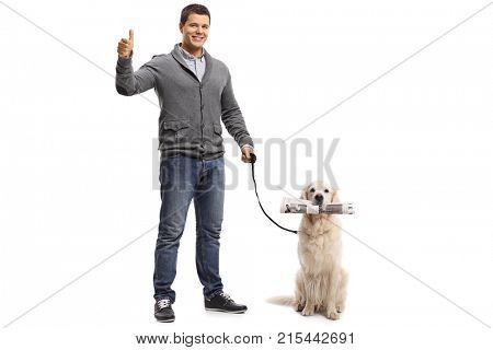 Full length portrait of a young man making a thumb up sign and a labrador retriever with a newspaper isolated on white background