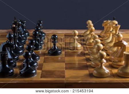Chess set on the chess board. Two pawns in the center.