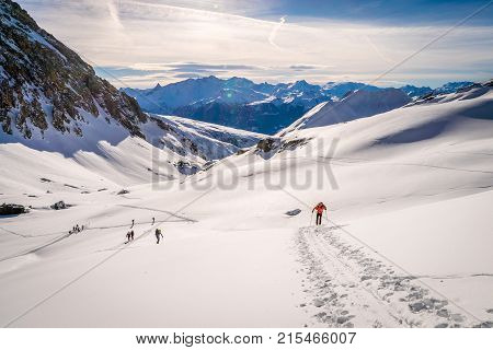 Ski touring in the Alps climbing the snowy mountains to reach a refuge