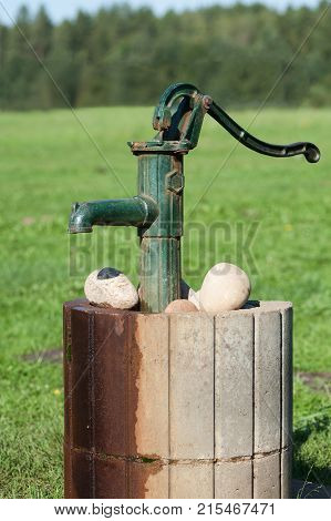 Old vintage water pump in countryside, Latvia