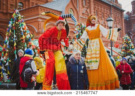 Russia. Moscow.Red square 26 Feb 2017. Carnival Maslenica . skomoroh and the clown among the crowd of people in the city centre