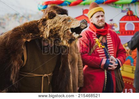 Russia. Moscow.Red square 26 Feb 2017. Carnival Maslenica . disguised in the skin of a bear entertains people on the street