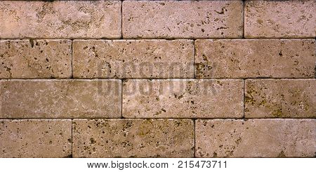 Stone wall texture, travertine tiles facing stone background