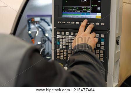 CNC operator programming lathe machine. Selective focus.