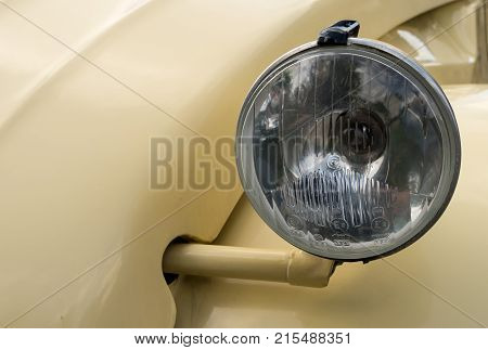 OSWESTRY, UK - SEPTEMBER 24, 2016: Headlamp of restored cream colored Citroen 2CV6 french car