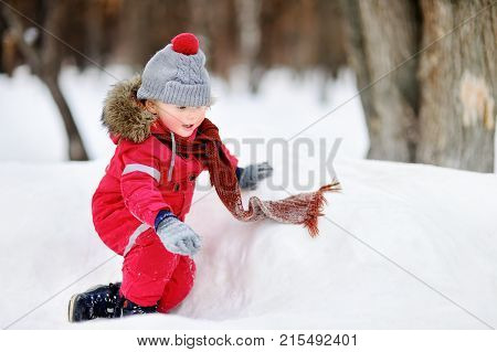 Little Boy In Red Winter Clothes Having Fun With Fresh Snow