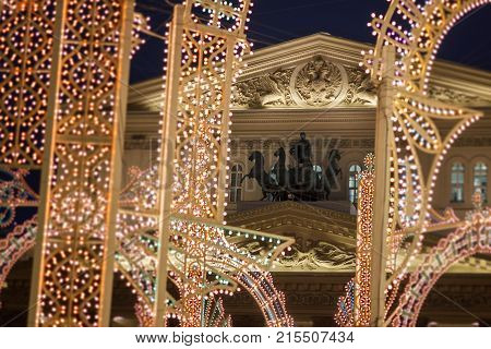 The bronze Quadriga and the emblem of the Russian Federation on State academic Bolshoi theatre of Russia in festive illuminations.