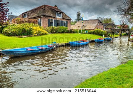 Stunning traditional touristic dutch village with colorful boats on the water canals and traditional decorated houses Giethoorn Netherlands Europe