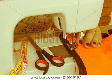 processes of sewing on the sewing machine sew women's hands sewing machine. Female tailor threading leather material on sewing machine. designer making a garment in her workplace