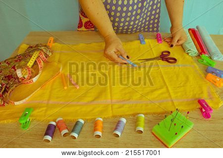 closeup of woman hands sewing yellow cloth outdoors. Woman's Hand Sewing Quilt